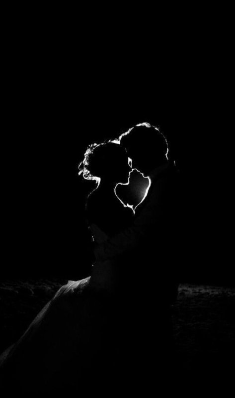 Силуэты пары на темном фоне