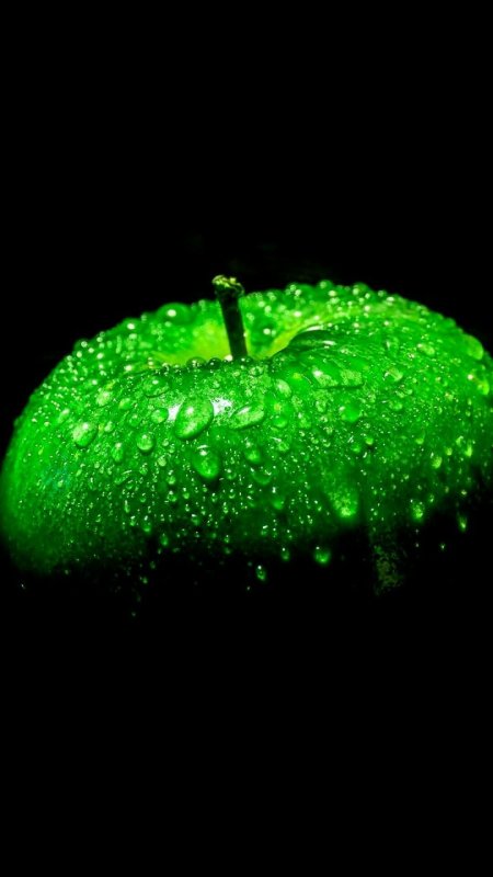 Зеленое яблоко на черном фоне