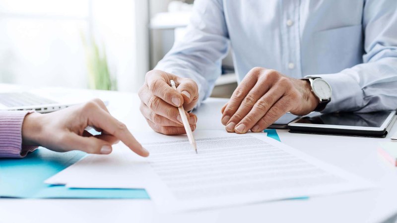 Человек подписывает бумаги