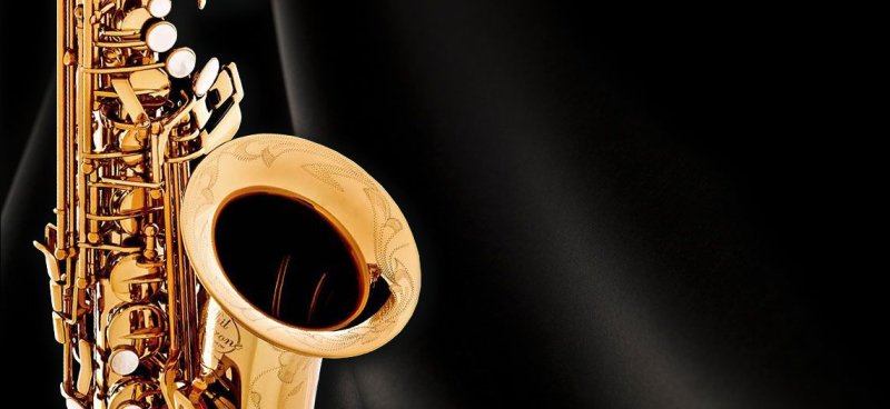 Саксофонист на чёрном фоне