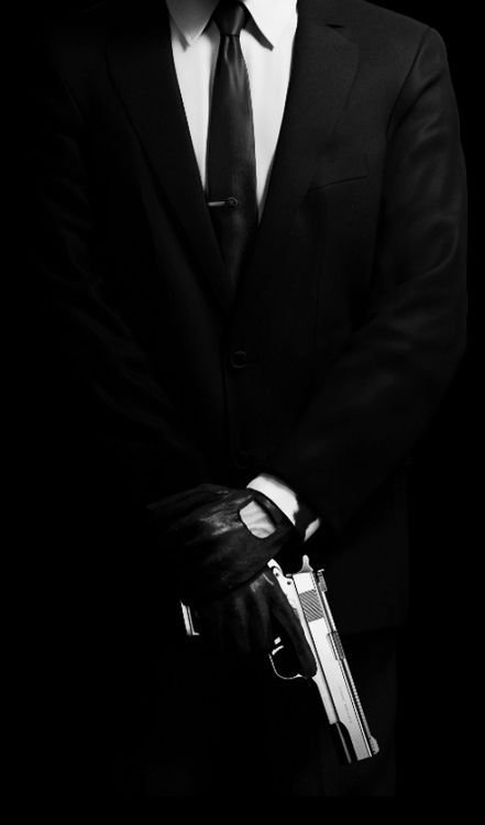 Парень в костюме с пистолетом